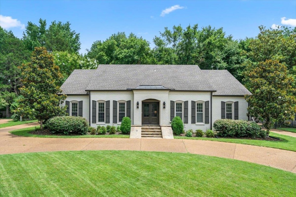 View of front facade featuring a front yard, french doors, and a shingled roof