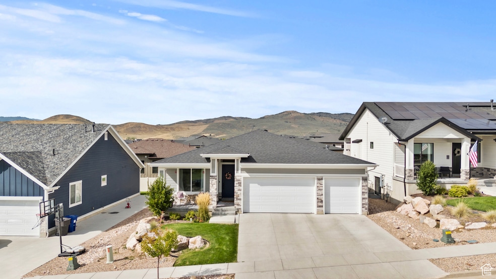 View of front of home featuring stone siding, a shingled roof, board and batten siding, and a mountain view