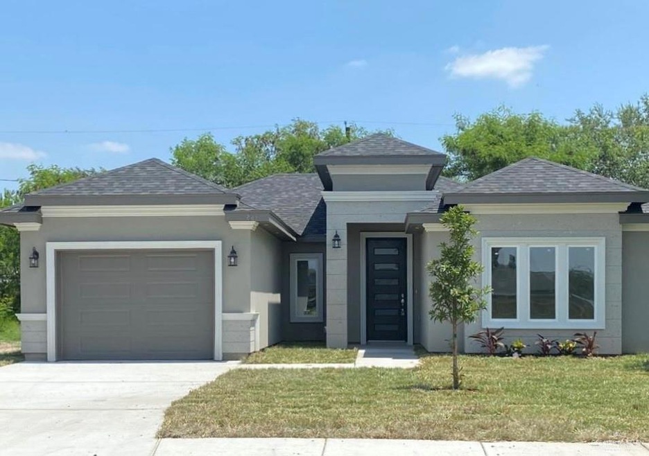 Prairie-style house featuring a garage and a front lawn
