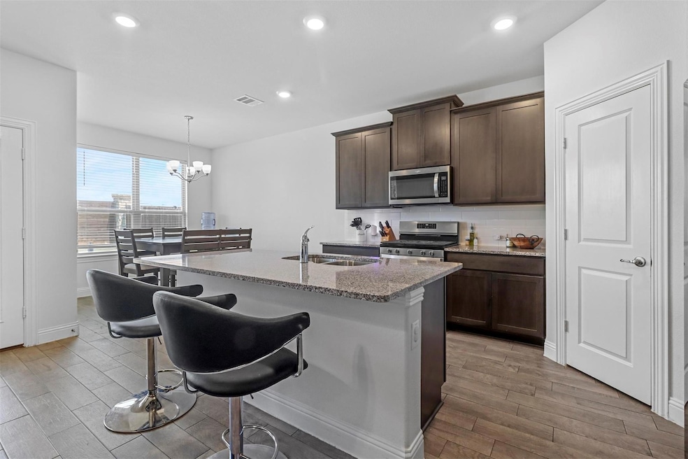 Kitchen featuring a kitchen island with sink, hang