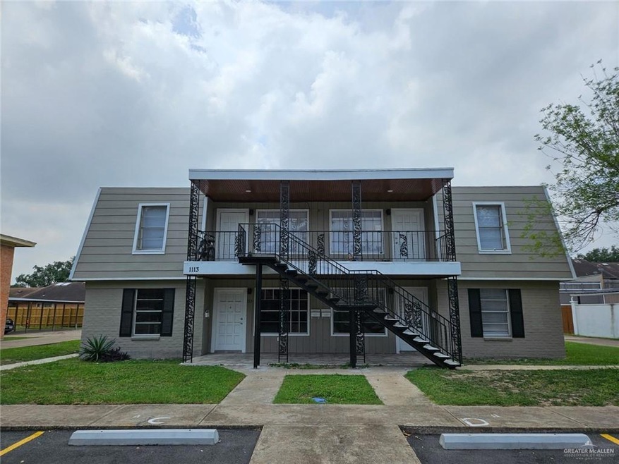 View of property with stairs, uncovered parking, and brick siding