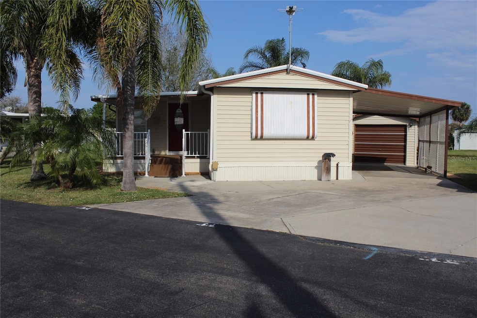 Front View with covered entrance, one car garage & carport