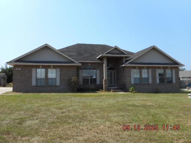 Single story home with brick siding and a front lawn