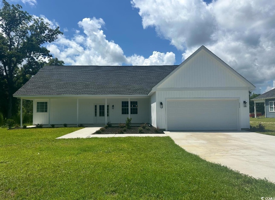 Ranch-style home featuring roof with shingles, a garage, concrete driveway, and a front yard