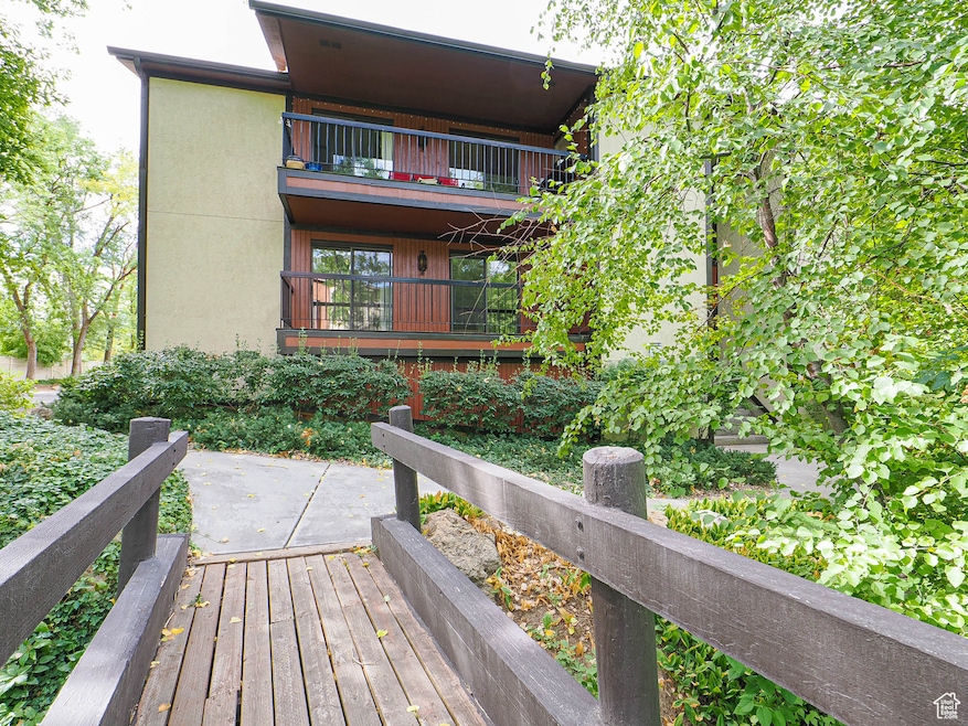 View of wooden deck overlooking lush greenery.