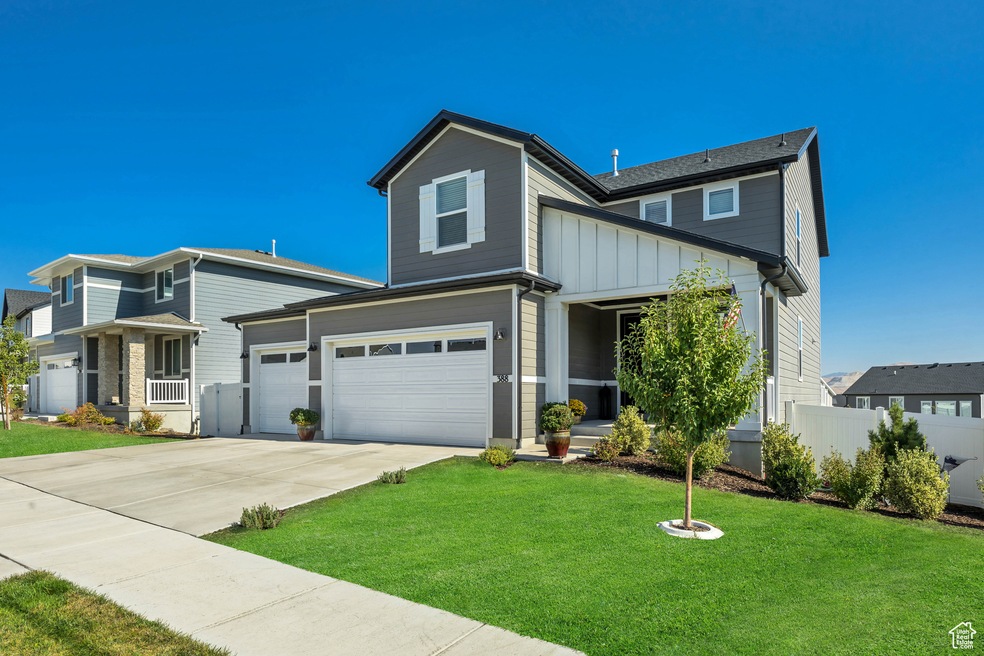View of front facade with driveway, board and batten siding, a porch, and an attached garage