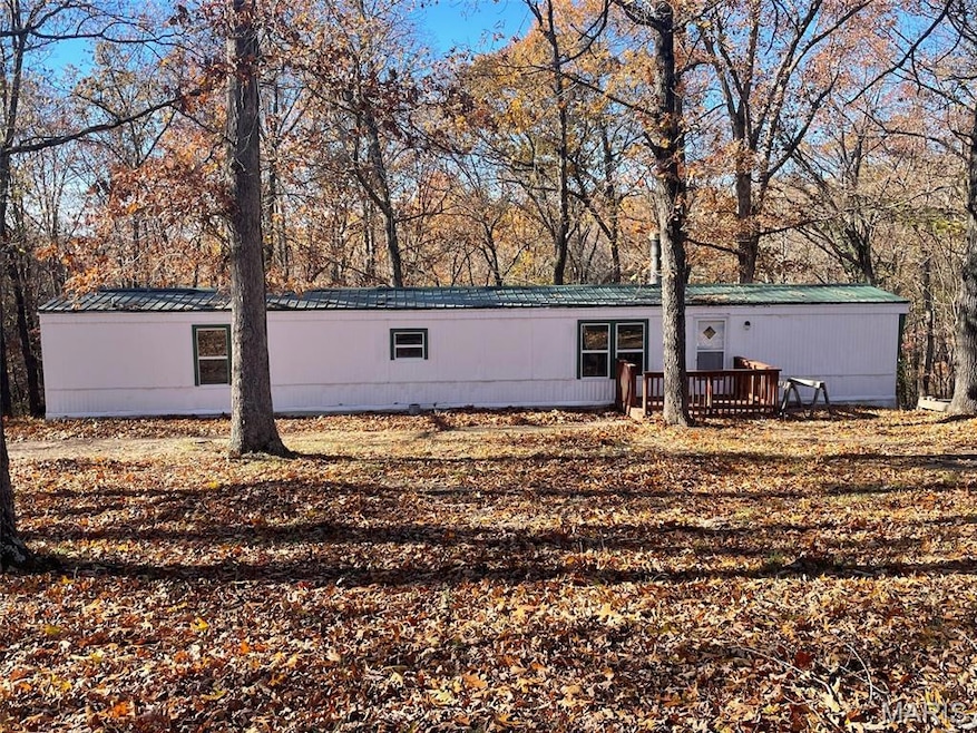 Rear view of house with view of wooded area