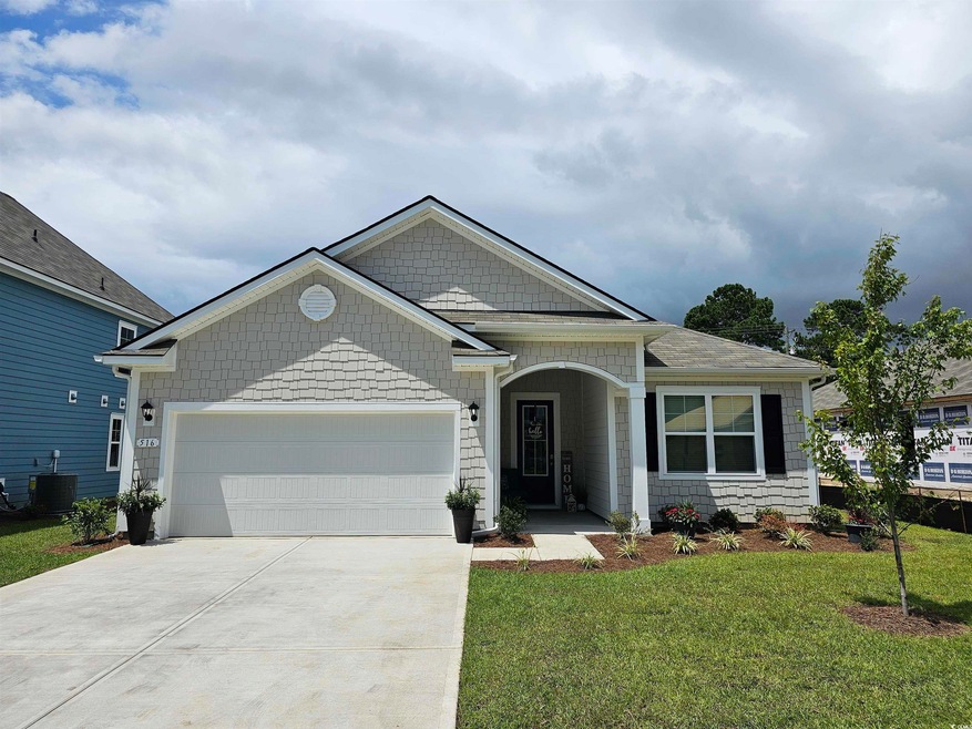 View of front of house featuring a garage, driveway, and a front yard