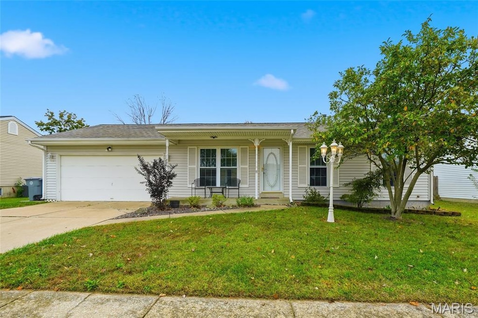 Single story home with a porch, a front yard, an attached garage, concrete driveway, and roof with shingles