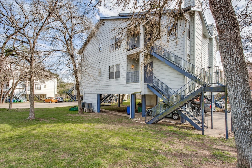 Rear view of property featuring stairs, a lawn, a