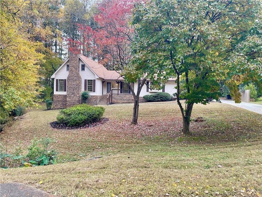 View of front facade featuring a front yard, a porch, and stone siding