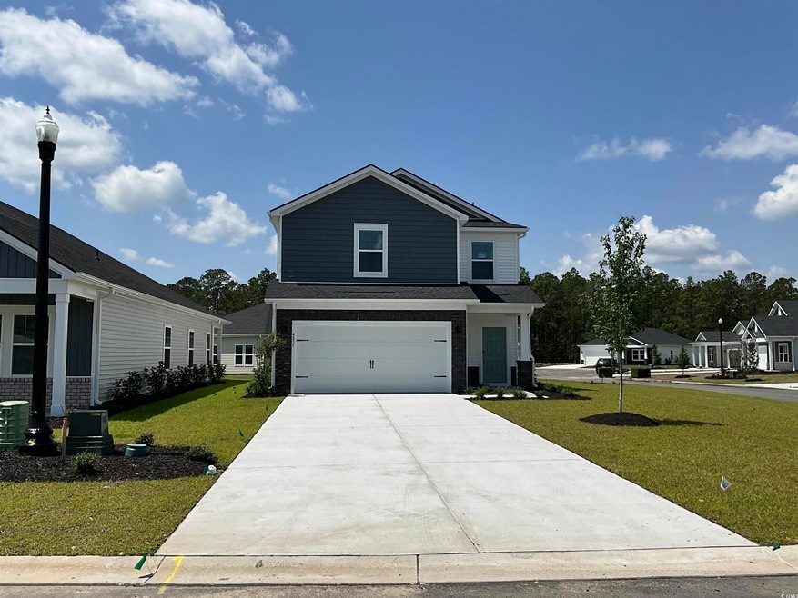 View of front facade with concrete driveway, a front yard, a garage, brick siding, and cooling unit