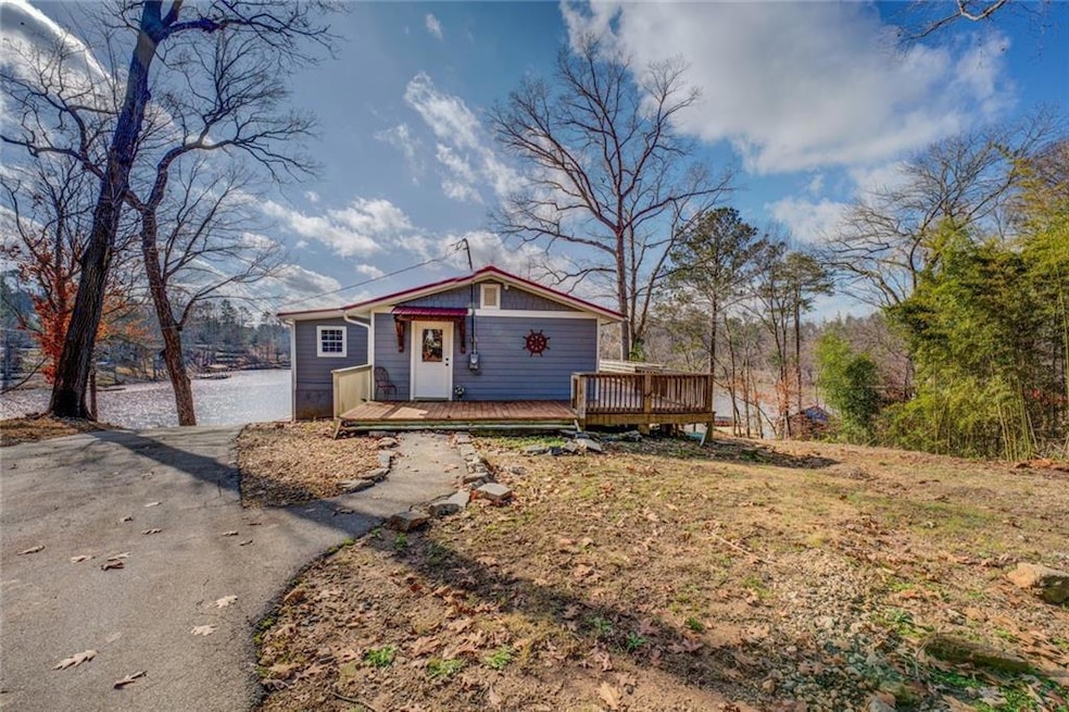View of front of home with driveway and a wooden d