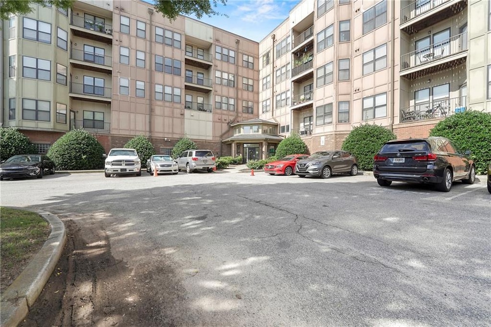 View of apartment building / complex with uncovered parking