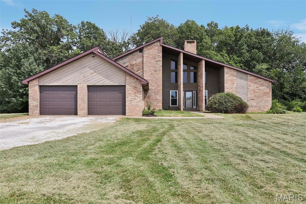 Mid-century inspired home with a front yard, a chimney, driveway, and brick siding