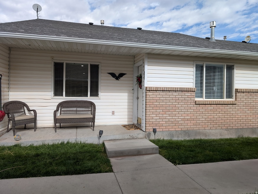 Doorway to property featuring a shingled roof and brick siding