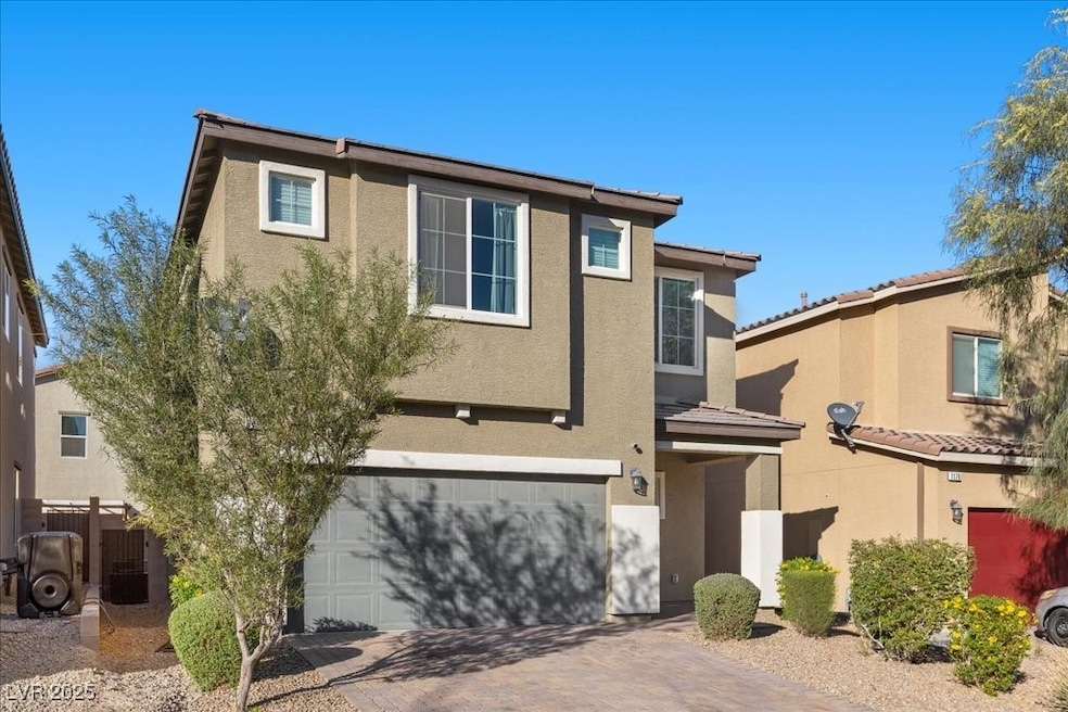 View of front of property with stucco siding, decorative driveway, a garage, and a tile roof
