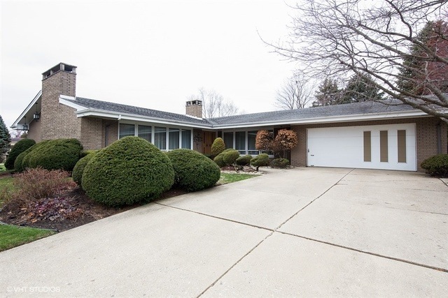 Extra wide concrete driveway leads to oversize hea