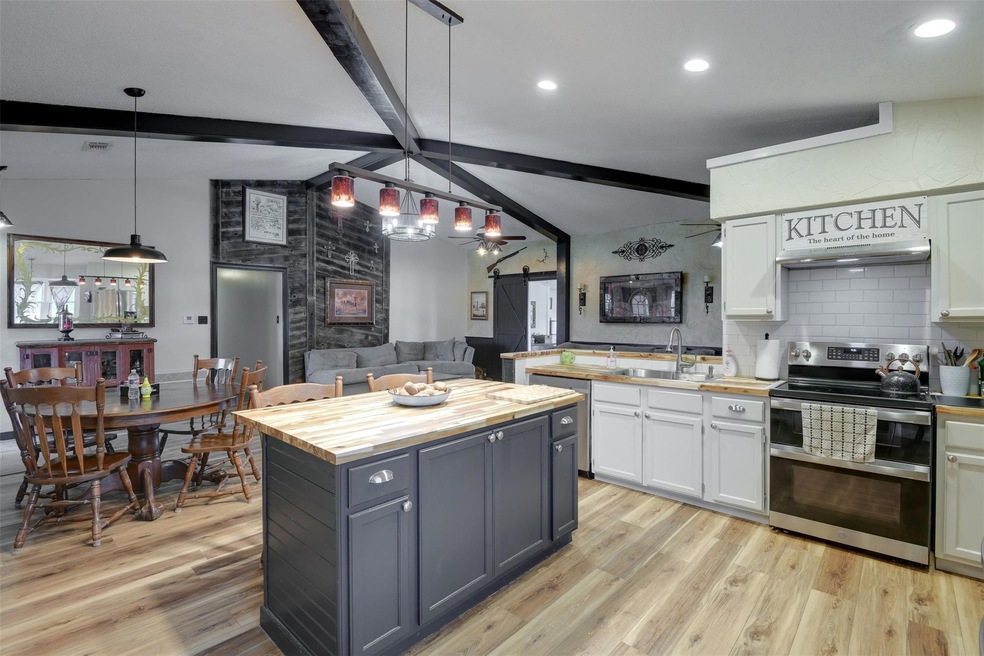 Kitchen with white cabinetry, light hardwood / woo