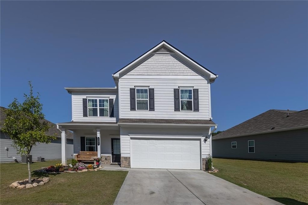 View of the property featuring the garage, porch a