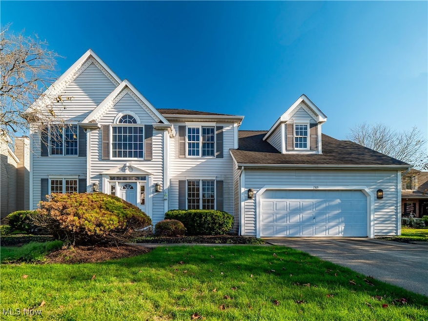 View of front of house with driveway, a front lawn, and an attached garage