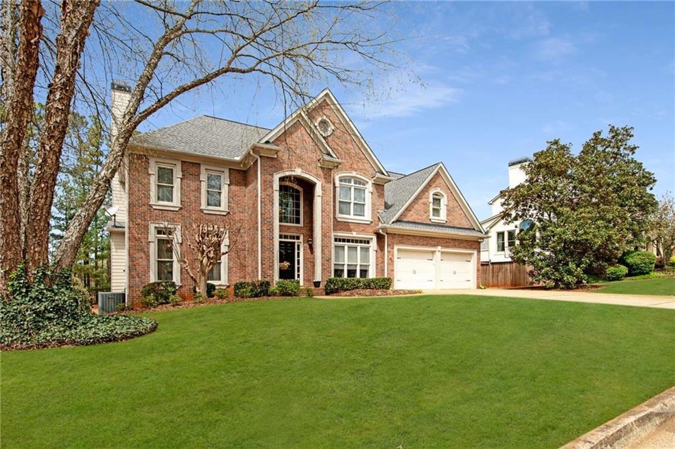 View of front of home featuring a front lawn, a ga