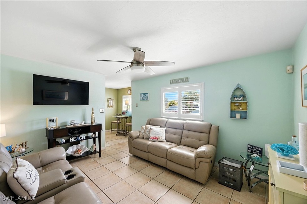 Living room featuring a ceiling fan and light tile
