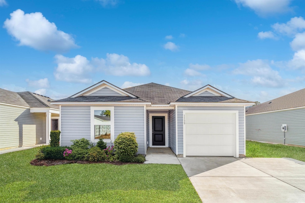 Ranch-style house featuring driveway, a garage, a front yard, and a shingled roof