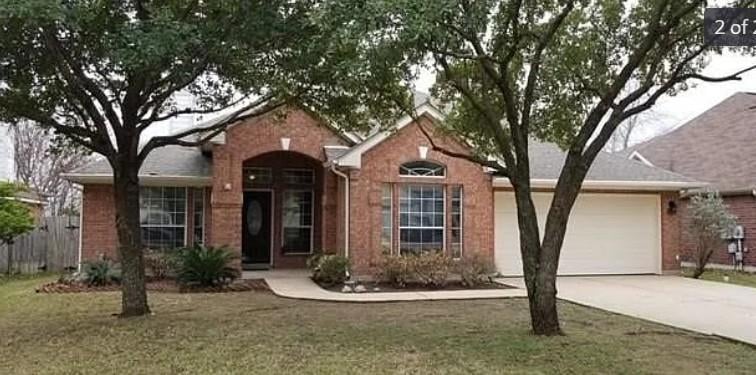 View of front of home with a garage, driveway, an