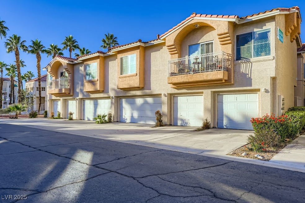 Mediterranean / spanish home with a balcony, stucco siding, a garage, and a tiled roof