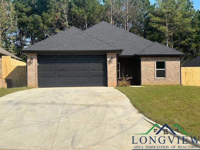 Single story home featuring a front yard and a gar