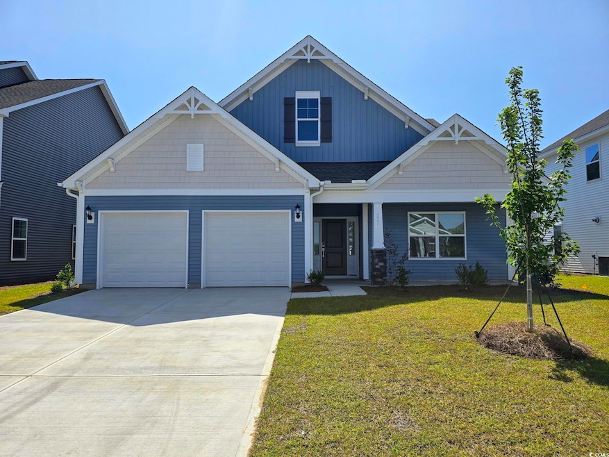 Craftsman house featuring concrete driveway, a front yard, an attached garage, and covered porch
