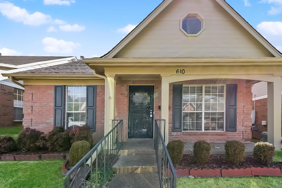 View of exterior entry featuring covered porch and a lawn