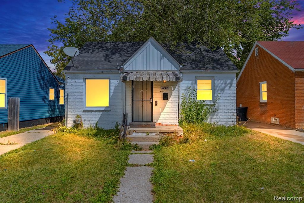 View of front of home with brick siding, a yard, a shingled roof, board and batten siding, and a standing seam roof