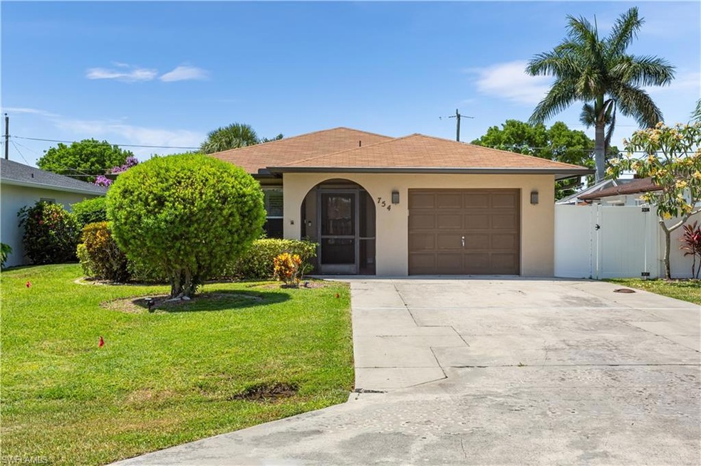 Ranch-style house featuring a front lawn and a gar