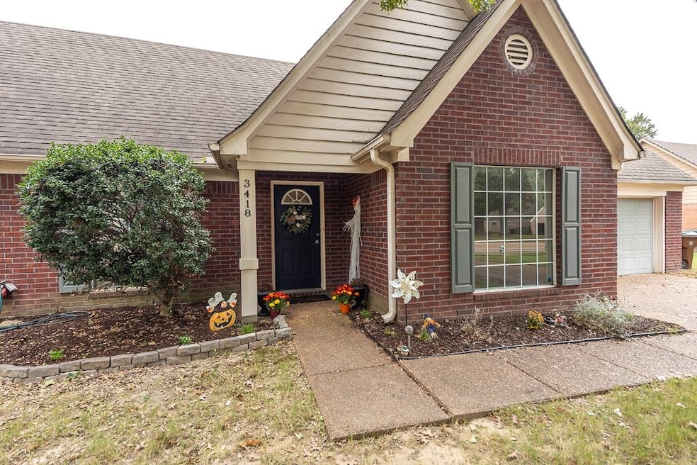 View of front of home featuring brick siding, a shingled roof, and a garage