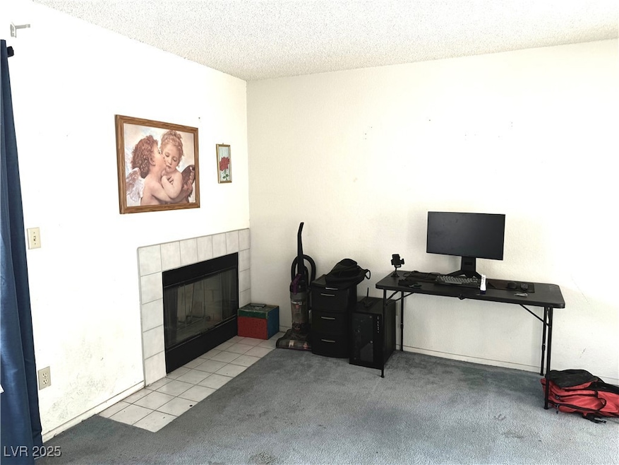 Carpeted Living room with a tile fireplace and a t