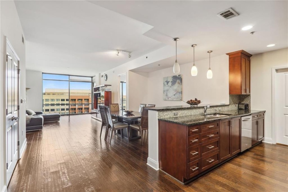 Kitchen with dark stone counters, dishwasher, backsplash, decorative light fixtures, and dark hardwood / wood-style flooring