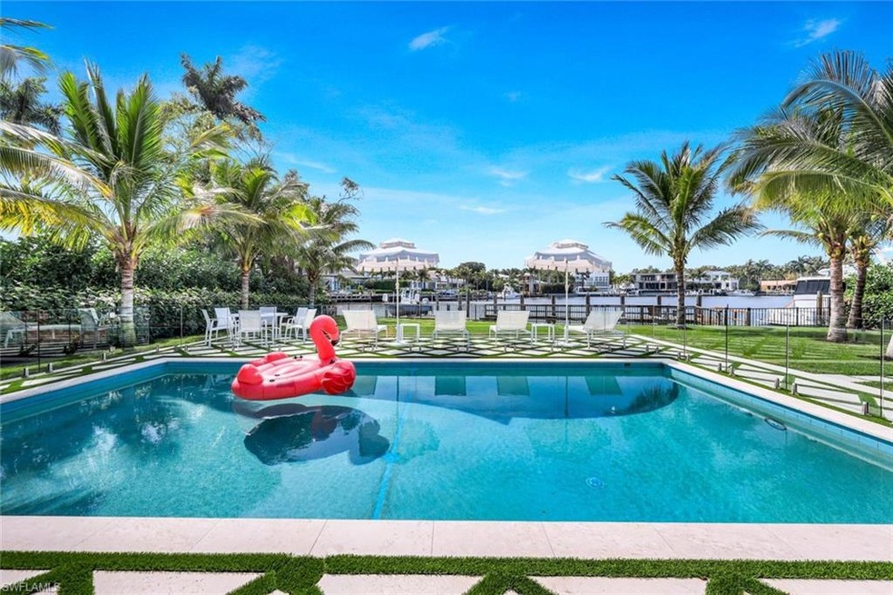 View of pool with a water view and a yard