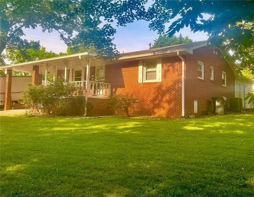 Rear view of house with a yard, covered porch, and