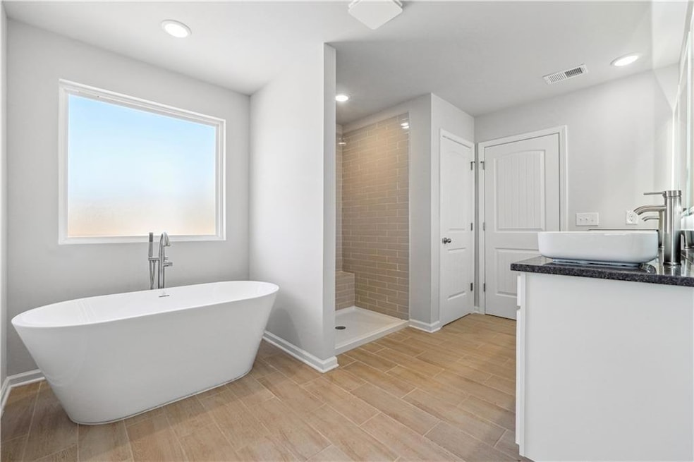 Full bath featuring a shower stall, a freestanding