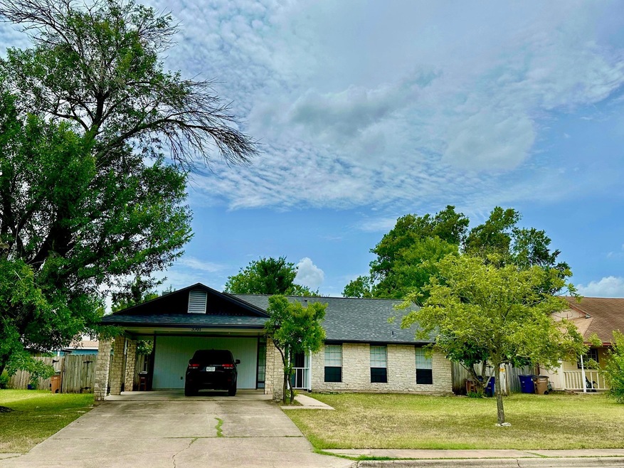 View of front facade with driveway, stone siding,