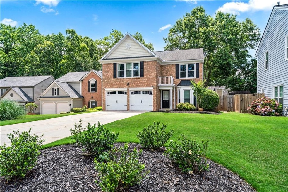 Traditional-style home featuring brick siding, a garage, and concrete driveway