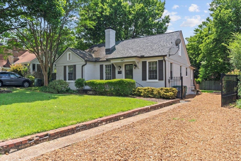 View of front of home featuring brick siding, a chimney, and roof with shingles