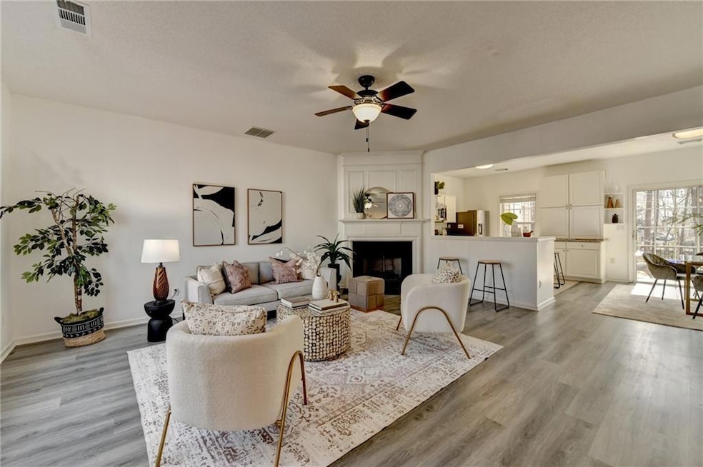 Living area with visible vents, a fireplace, and l