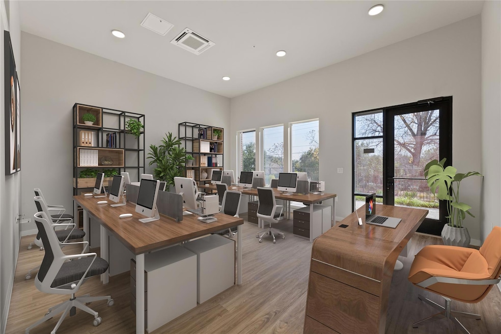 Office with light wood-style floors and recessed 
