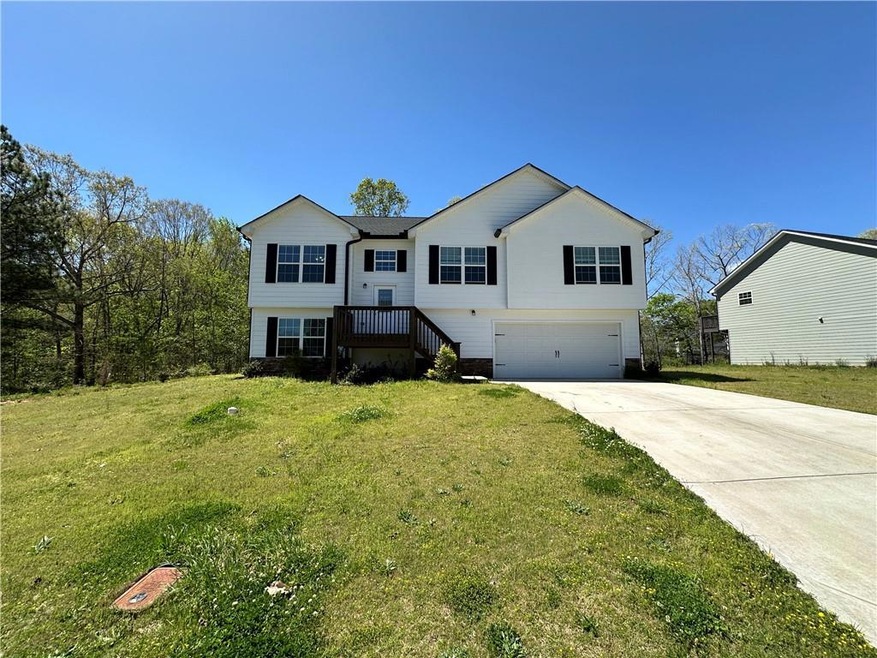 Split foyer home featuring a garage and a front ya