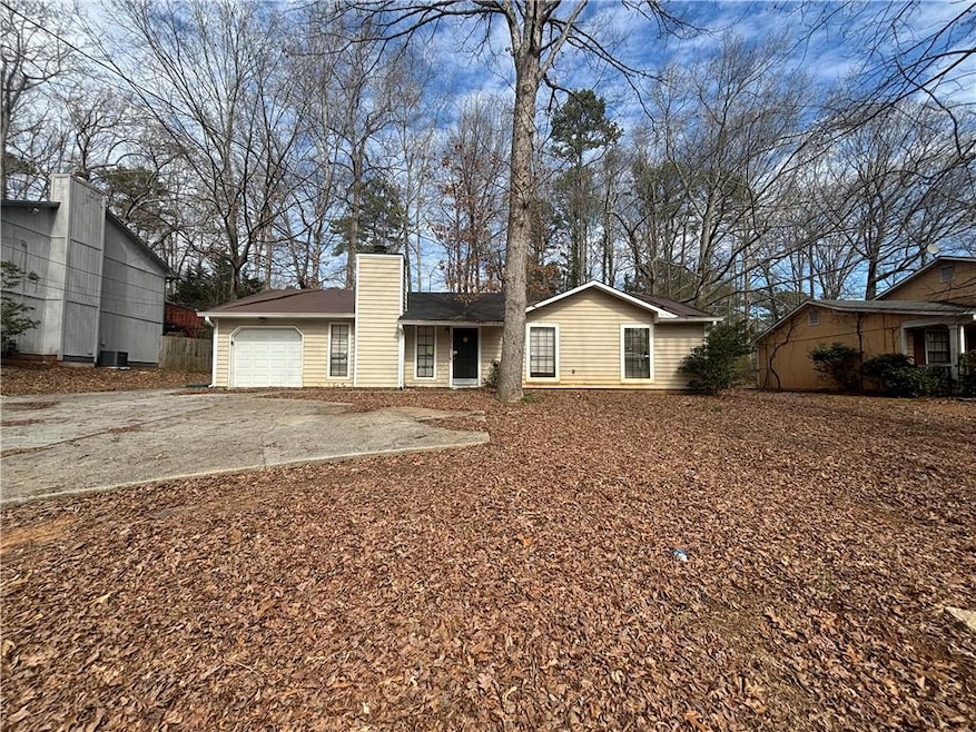 View of front of house featuring driveway, a chimn