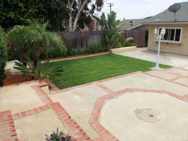 Reverse view of backyard with grass and large pati