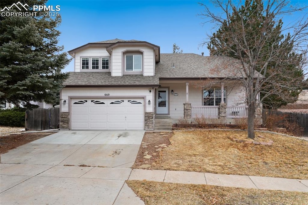 View of front of house with a shingled roof, fence, concrete driveway, covered porch, and an attached garage